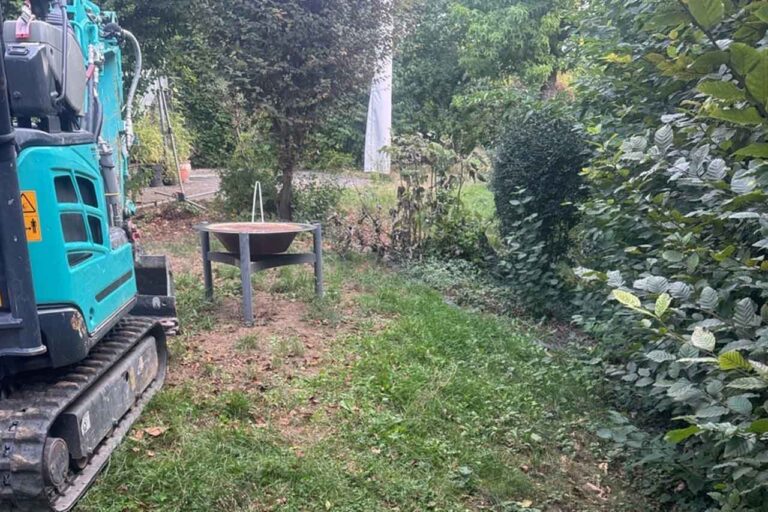 Minibagger beim Abtrag des Oberbodens für die Erweiterung der Rasenfläche