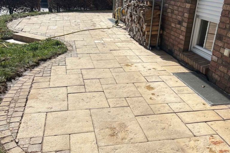 Gereinigte Natursteinterrasse mit Granitplatten und Pflasterintarsie